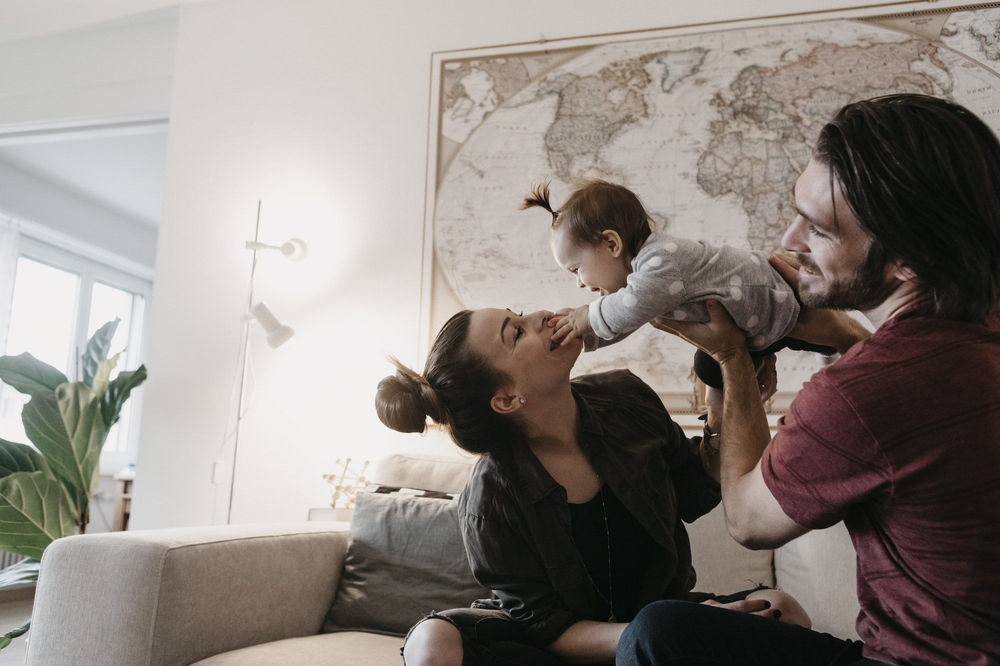 Happy family playing with baby girl in living room at home